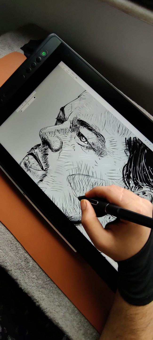 Hand in glove draws a face on a graphics tablet.
