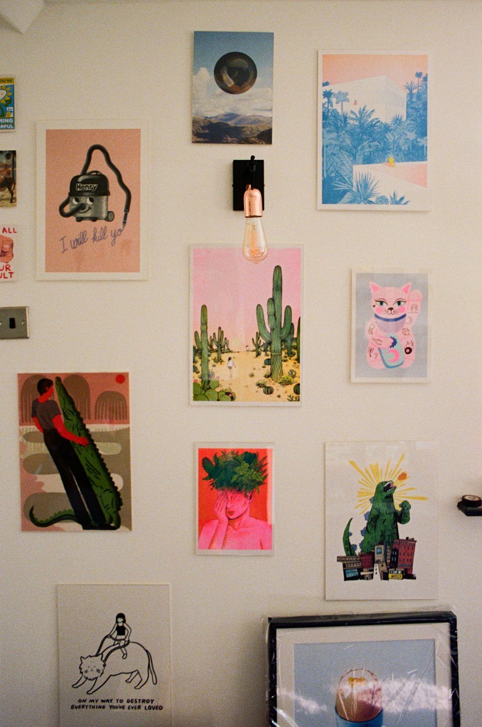 Eclectic art prints displayed on a clean white wall.