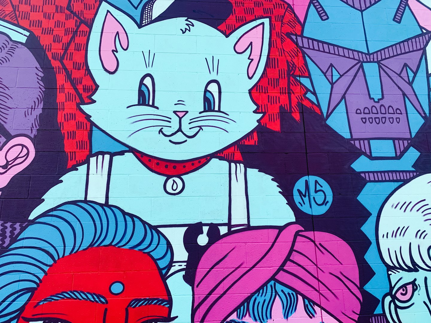 A large blue cartoon cat mural painted on brick.