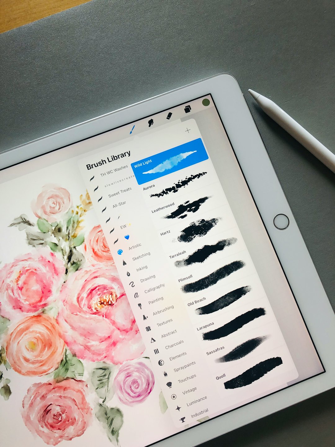 Digital tablet showing brush settings beside a stylus pen.